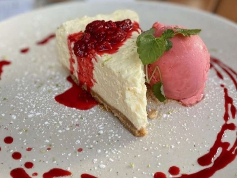 Delicious cheesecake served at The Recruiting Sergeant, topped with berry sauce and accompanied by a scoop of fruit ice cream and fresh mint.