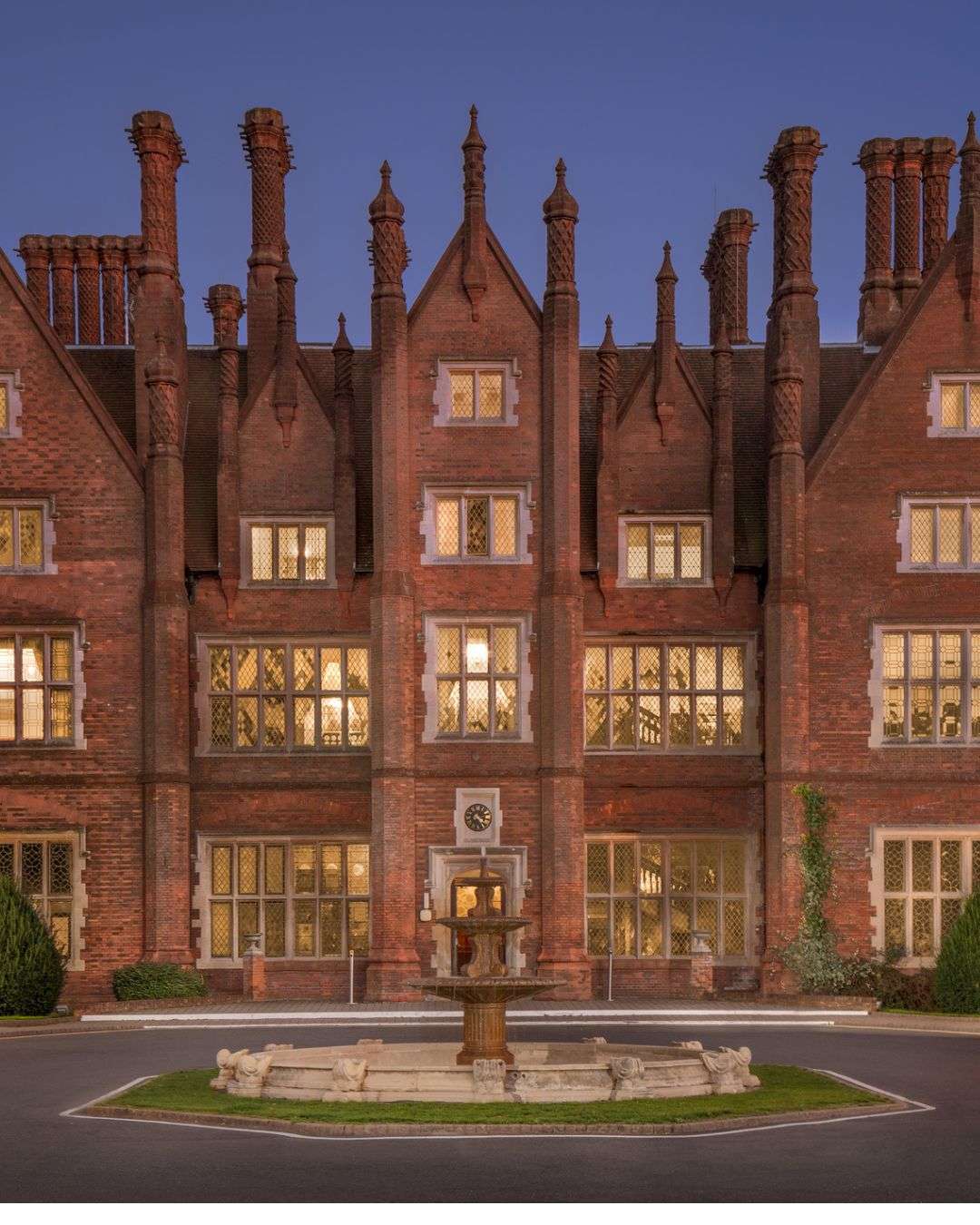 Historic Dunston Hall red-brick frontage with ornate gables and distinctive Tudor-style architecture.
