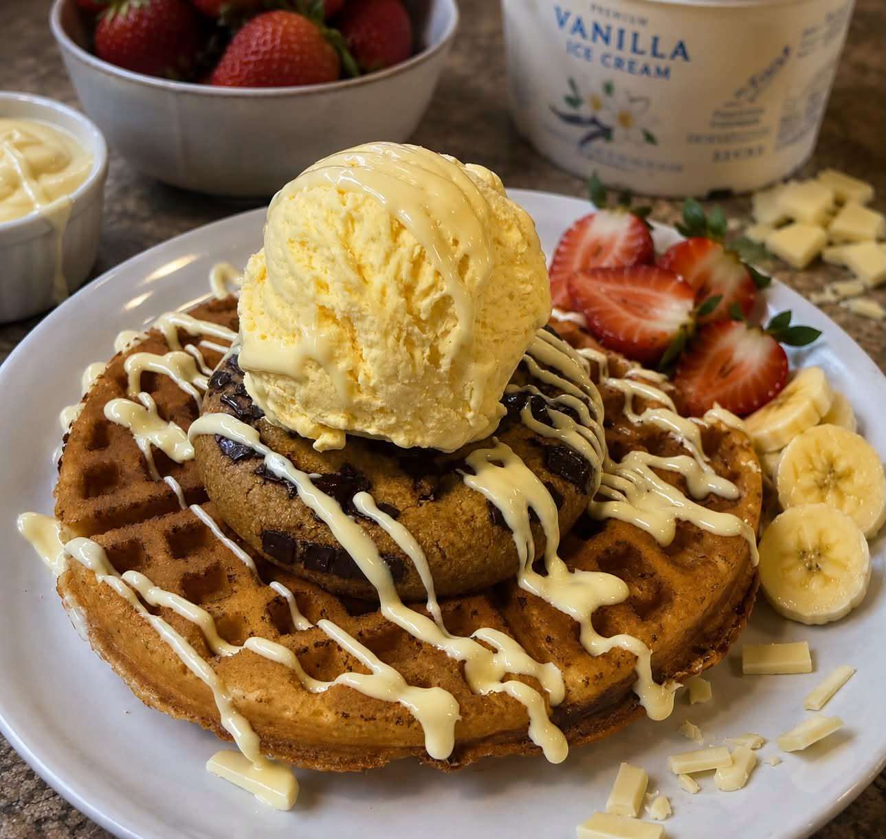 Freshly made waffle topped with vanilla ice cream, chocolate sauce, sliced bananas and strawberries, served at Scooters Café.