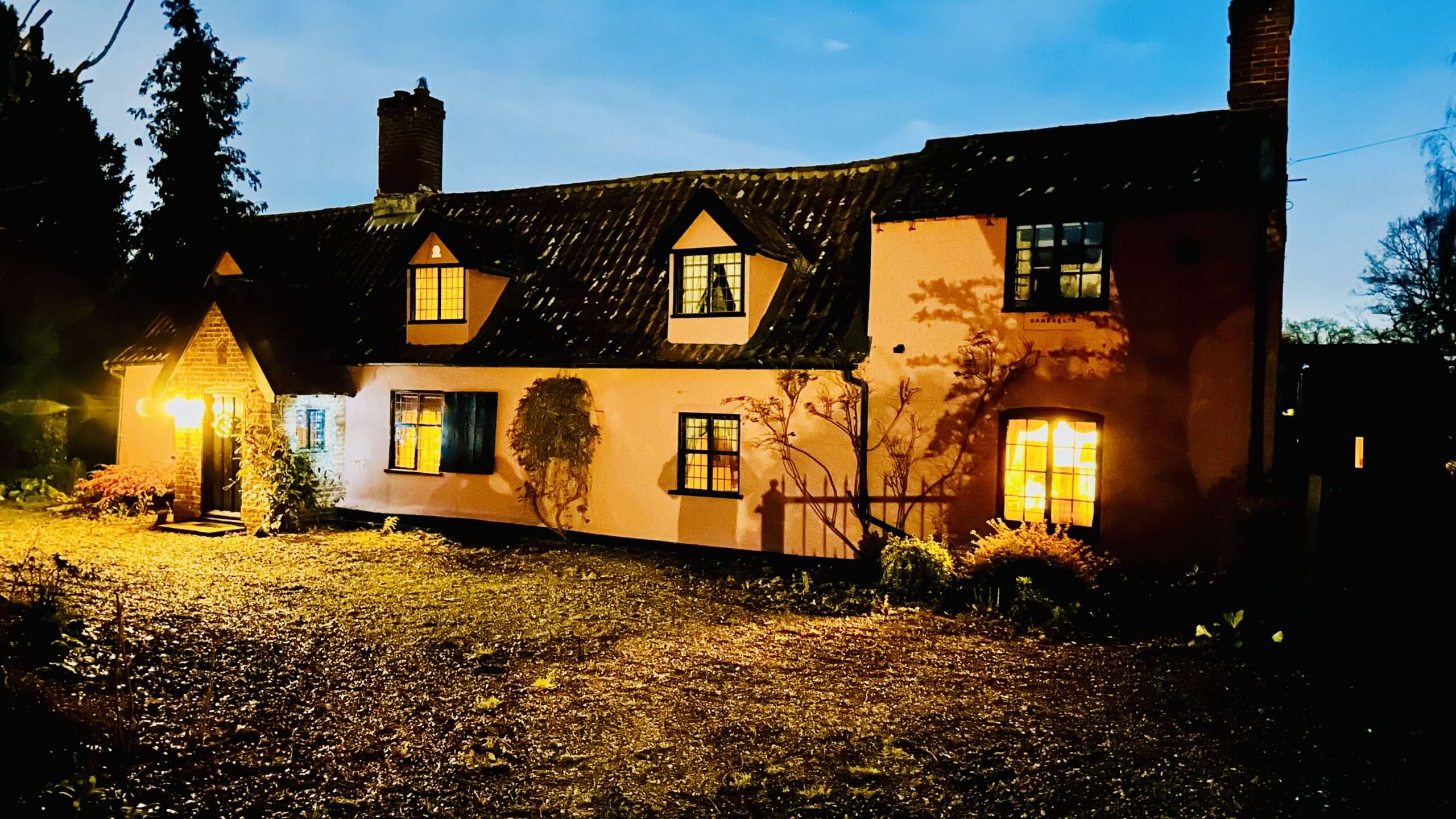 Danegelts accommodation illuminated at night with traditional Norfolk character.
