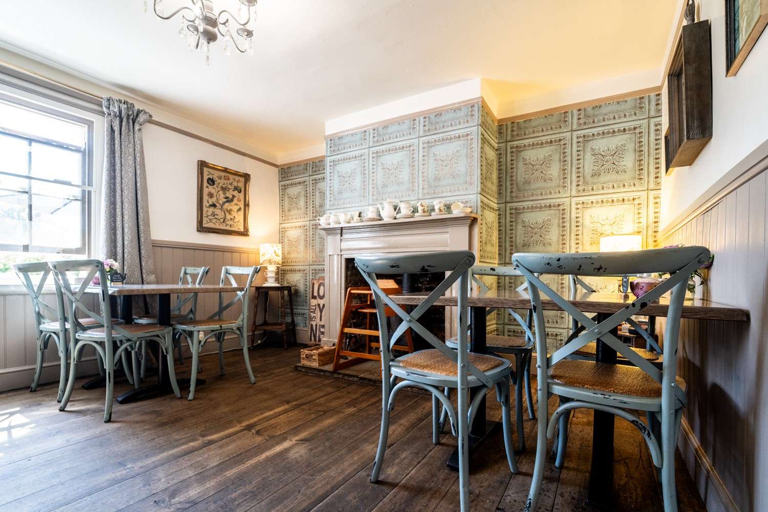 Tea room interior with tables, chairs and vintage-style décor creating a welcoming atmosphere.