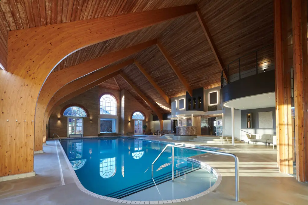 Indoor swimming pool with vaulted timber ceiling at Park Farm Hotel.