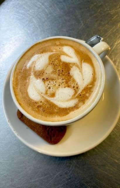 Freshly prepared cappuccino with latte art served at Zoe's café.